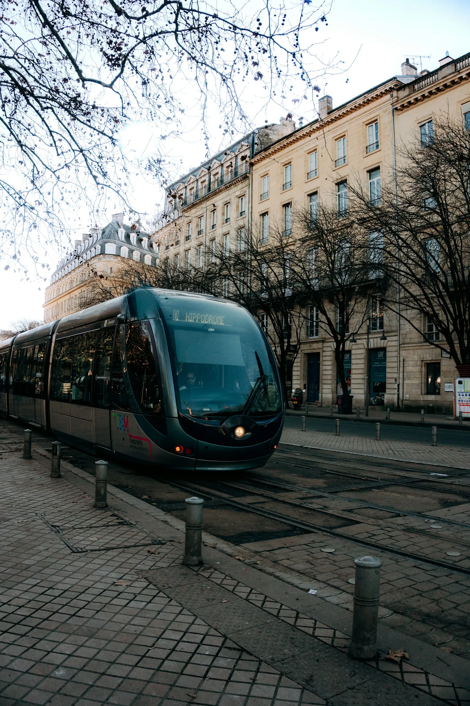 Un tramway circule devant des immeubles en pierre claire dans le centre de Bordeaux