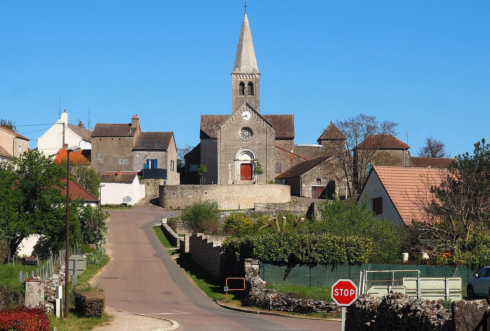 Le village d’Aluze et le clocher de l’église Saint-Martin sous un ciel bleu