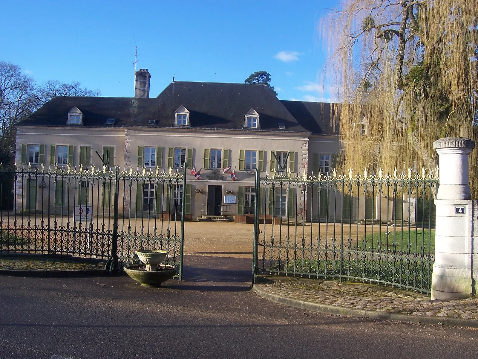 Le château de Châtenoy-en-Bresse, qui abrite la mairie, vu depuis sa grille d’entrée