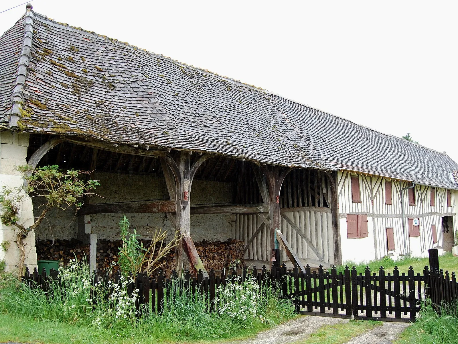 Une ancienne ferme à colombages et son auvent de bois aux Églisottes-et-Chalaures