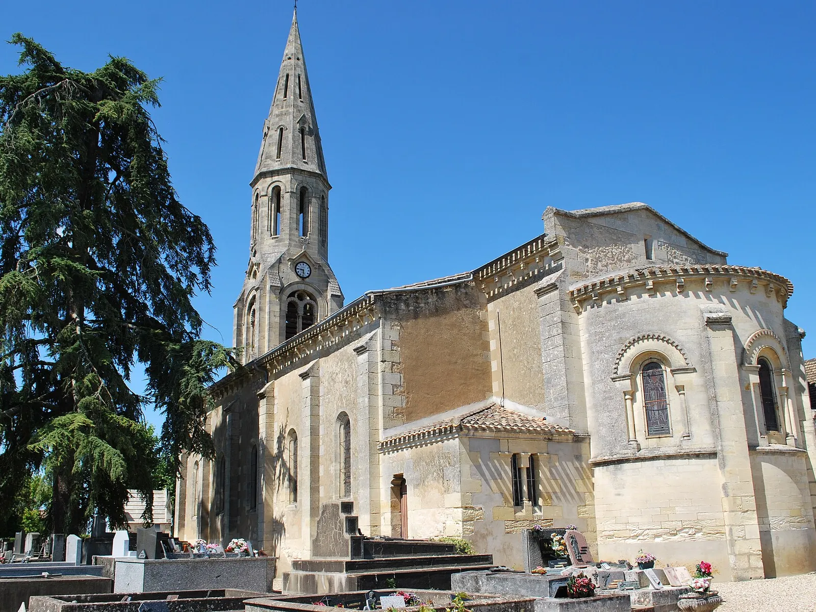 L’église Saint-Brice de Néac, son clocher en flèche et son abside, vus depuis le cimetière