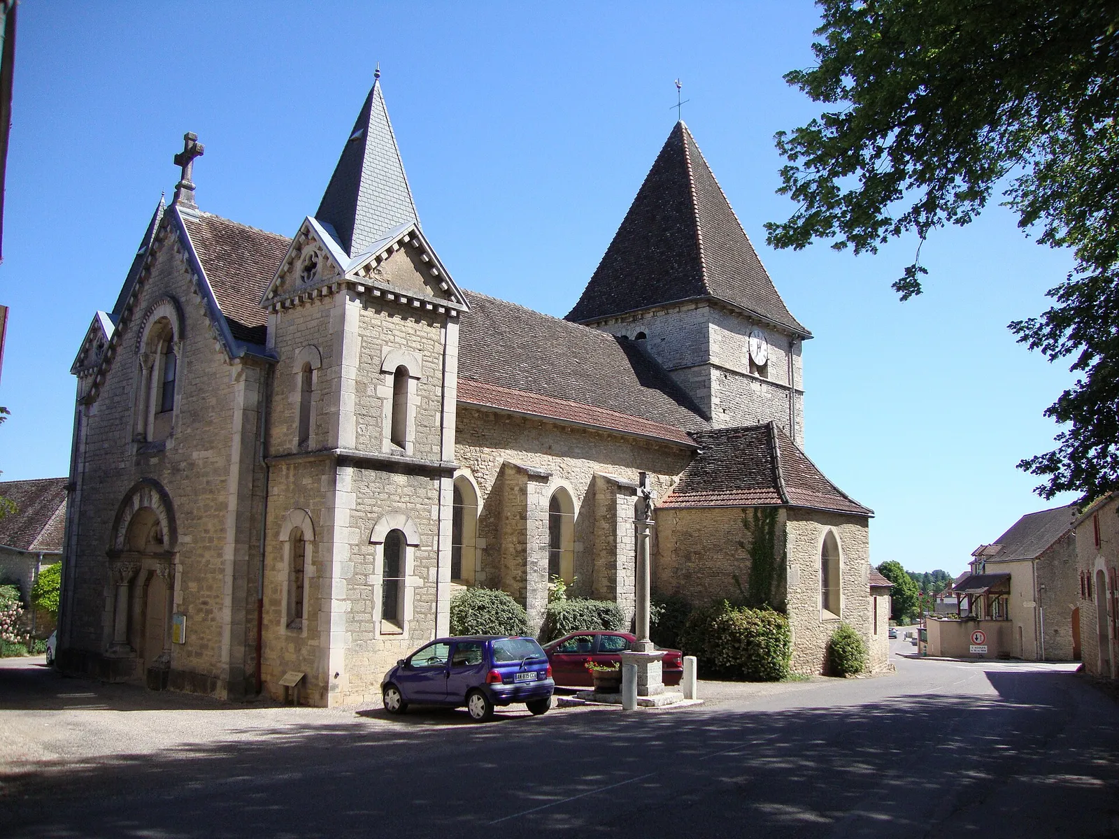 L’église de Remigny et la rue qui la longe, sous un ciel bleu