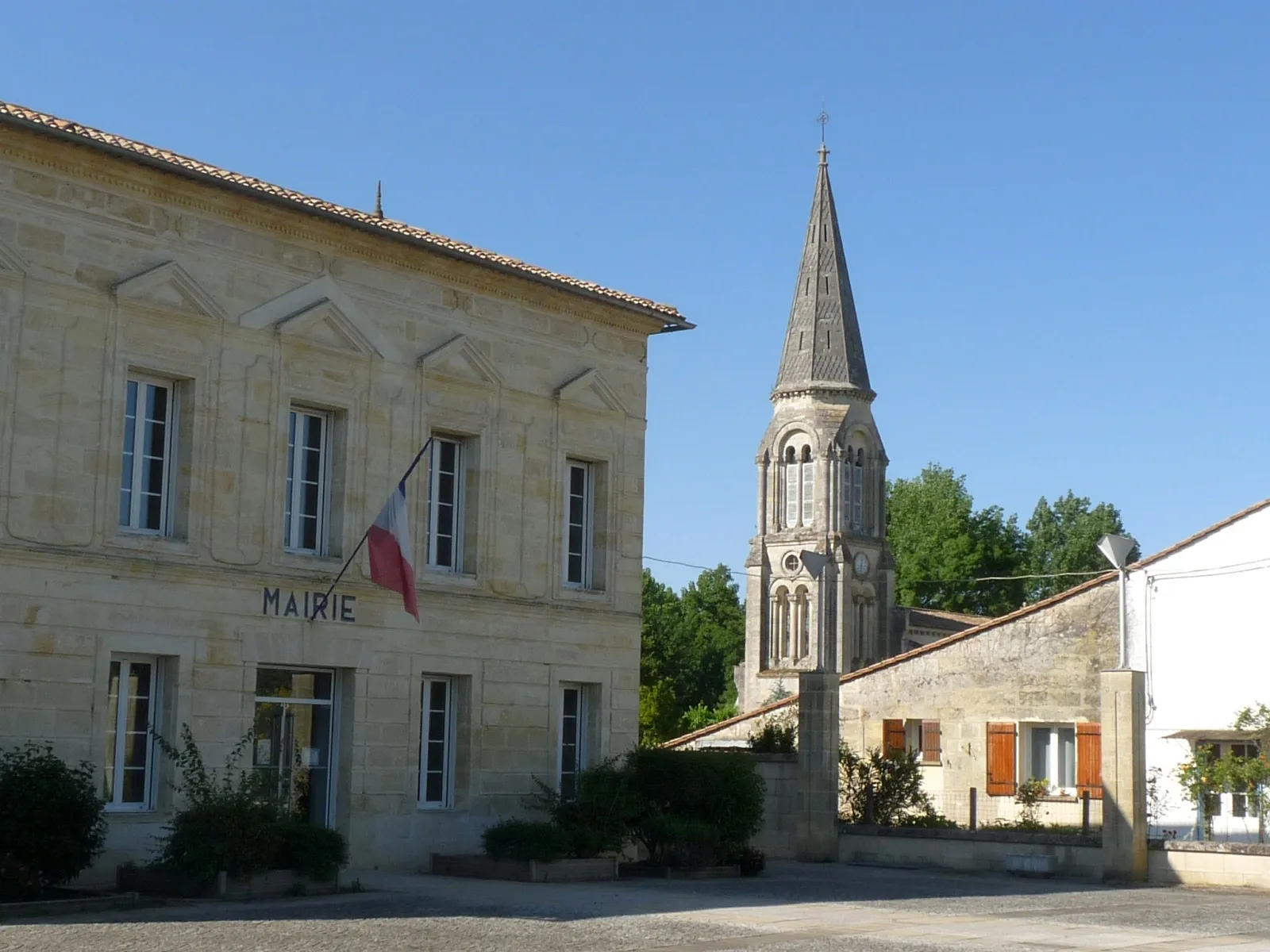 La mairie en pierre et le clocher de l’église Saint-Martin, au bourg de Sablons