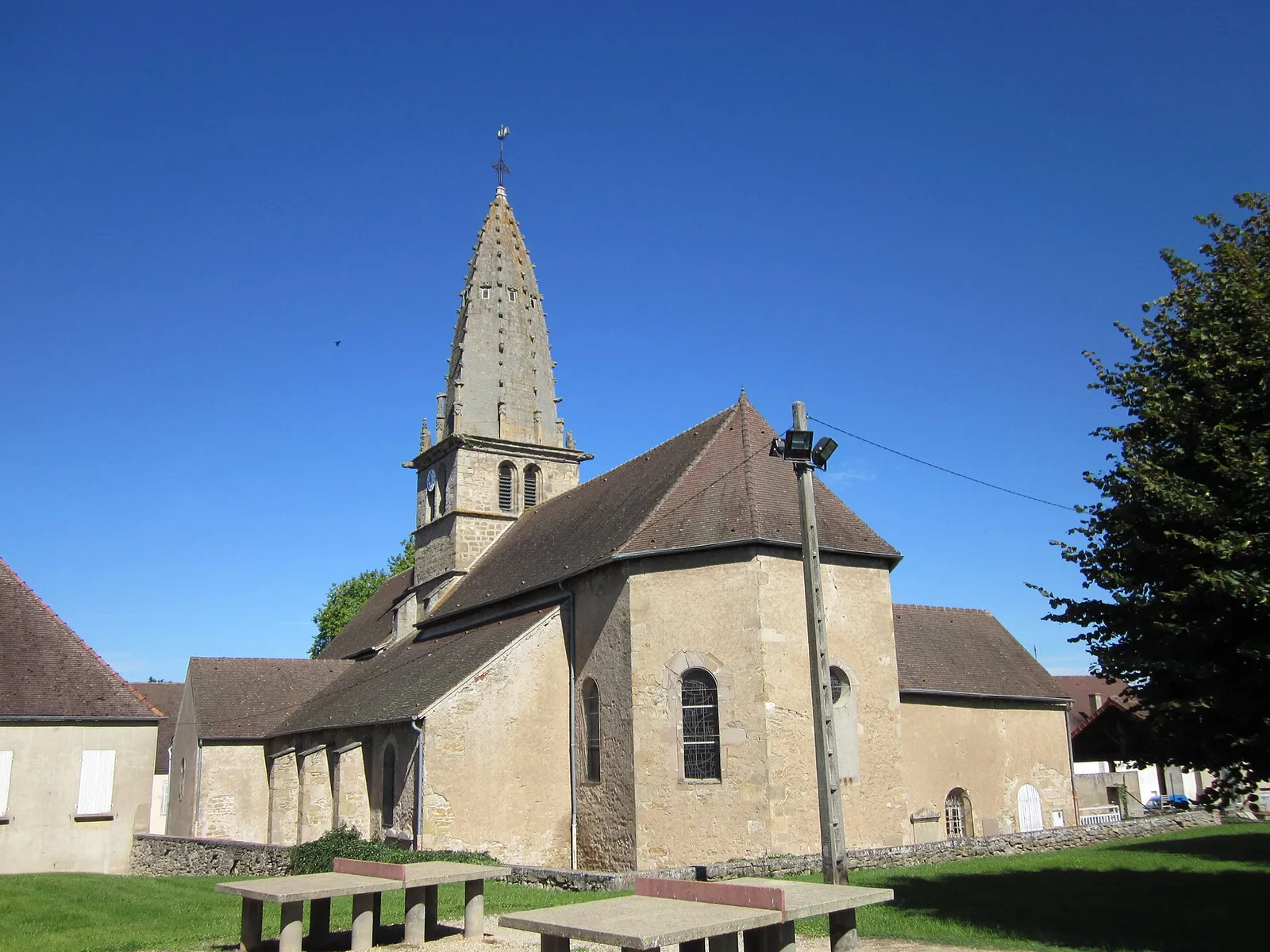 L’église romane de Saint-Léger-sur-Dheune et son clocher octogonal en pierre, sous un ciel bleu