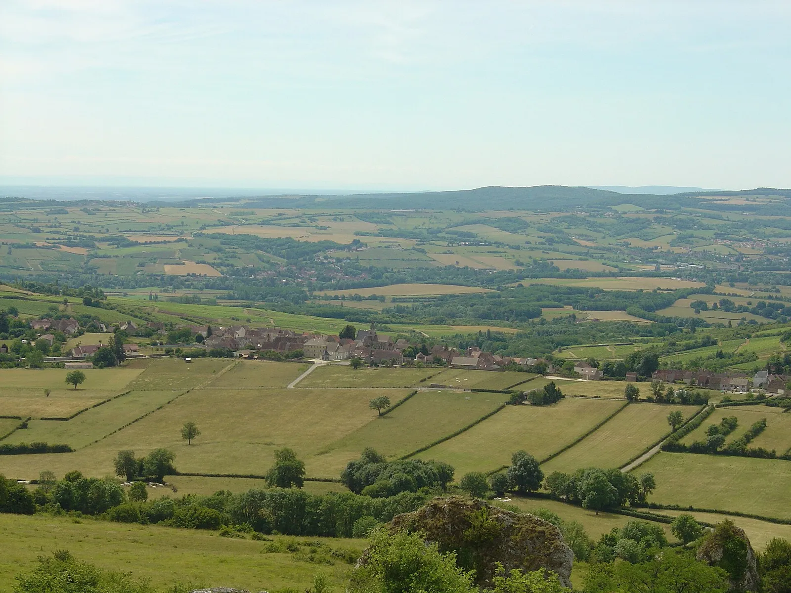 Le village de Saint-Sernin-du-Plain au milieu des prés, vu depuis le mont Rome
